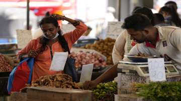 A woman bargains as she buys vegetables at a market place in Colombo, Sri Lanka. 