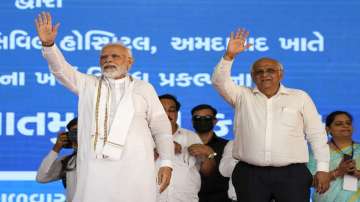Prime Minister Narendra Modi and Chief Minister of Gujarat Bhupendra Patel wave during an event in Ahmedabad.