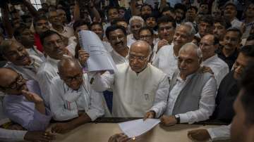 Senior Congress party leader Mallikarjun Kharge, center, shows his documents as he files his nomination papers for Congress party president at the party's headquarter in New Delhi on Sep 30.