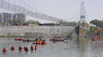 Rescuers on boats search in the Machchu river next to a cable bridge that collapsed in Morbi town of western state Gujarat.