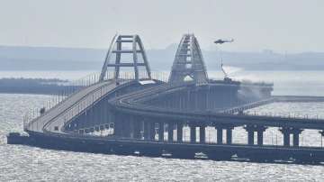 A helicopter drops water to stop fire on Crimean Bridge connecting Russian mainland and Crimean peninsula over the Kerch Strait, in Kerch, Saturday, Oct. 8, 2022.