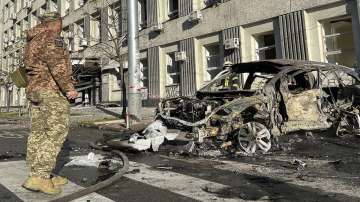 Rescue workers survey the scene of a Russian attack on Kyiv, Ukraine