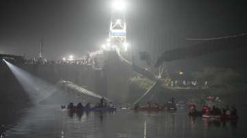 Rescuers on boats search in the Machchu river next to a cable suspension bridge that collapsed in Morbi town of Gujarat.