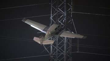A small plane rests on live power lines after crashing, Sunday, Nov. 27, 2022, in Montgomery Village, a northern suburb of Gaithersburg. 