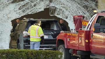 Worker use a tow truck to remove a damaged SUV from inside an Apple store, Monday, Nov. 21, 2022, in Hingham, Mass.