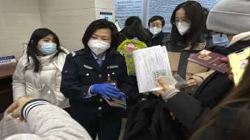 An officer collects passports from residents for renewal and re-applications at a community police station in Beijing.