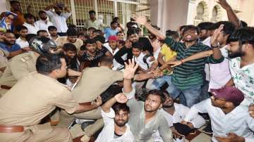 Police detain students who had gathered outside the Vice Chancellors office at the Allahabad Central University during a protest against the fee hike, in Prayagraj.