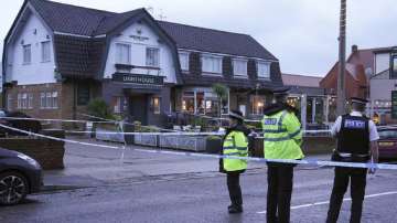 Police officers stand on duty at the Lighthouse Inn in Wallasey Village, near Liverpool, England, Sunday, Dec. 25, 2022.