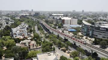 An aerial view of a train running on its tracks after Delhi Metro services.