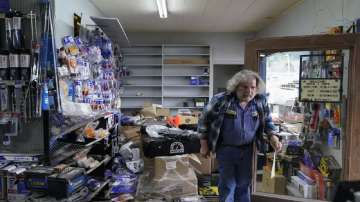 Kenny Ransbottom walks through debris inside his auto parts store after an earthquake in Rio Dell.
