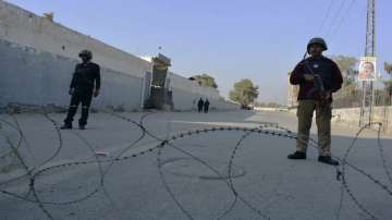 Security officials guard a blocked road leading to a counter-terrorism centre after security forces starting to clear the compound seized earlier by Pakistani Taliban militants in Bannu.