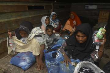 Ethnic Rohingya women and children sit at the back of a military truck upon arrival at a temporary shelter after their boat landed in Pidie, Aceh province, Indonesia.