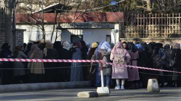 Afghan students queue at one of Kabul University's gates in Kabul. Women are banned from private and public universities in Afghanistan with immediate effect and until further notice, a Taliban government spokesman said.