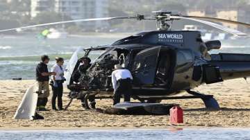 Two cashed helicopters sit on the sand at a collision scene near Seaworld, on the Gold Coast.