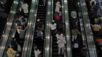 Travelers ride on the escalator as they arrive at the West Railway Station in Beijing, China (Representational image)
