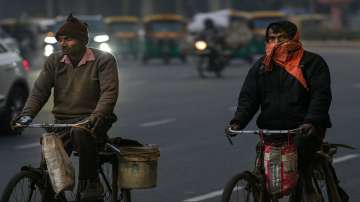 Commuters ride bicycles on a cold winter evening, in New Delhi.