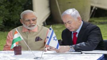Indian Prime Minister Narendra Modi, left, and Israeli Prime Minister Benjamin Netanyahu, sign the guest book at the World War I Indian Army cemetery, in the Israeli coastal city of Haifa.