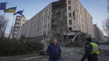 People stand in front of a damaged hotel at the scene of Russian shelling in Kyiv, Ukraine