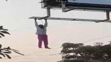 Drunk man hangs from billboard frame in Telangana.