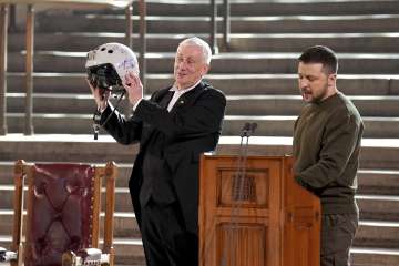 Speaker of the House of Commons, Sir Lindsay Hoyle, left, holds the helmet of one of the most successful Ukrainian pilots, inscribed with the words "We have freedom, give us wings to protect it", which was presented to him by Ukrainian President Volodymyr Zelenskyy as he addressed parliamentarians.