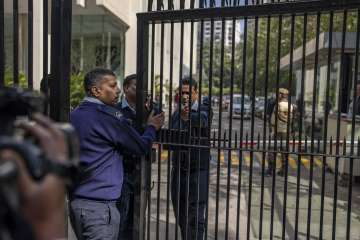 Private security guards close the gate of a building housing BBC office in New Delhi, India. 