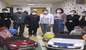 Children drive to their treatment rooms on electric toy cars.