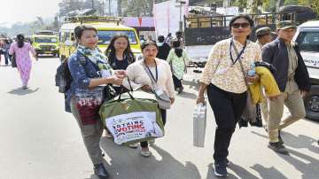 Women polling officials with electronic voting machine (EVM) and other election materials head towards their respective polling stations for the Meghalaya Assembly elections.