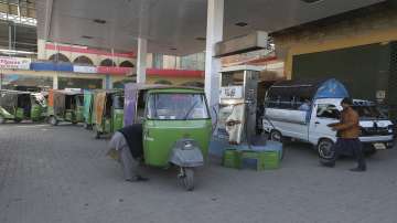 People wait their turn for filling gas into their vehicles gas at a CNG station, in Peshawar, Pakistan