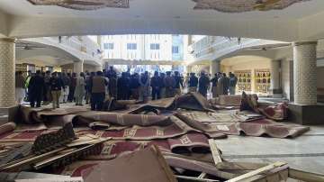 Security officials and rescue workers gather at the site of suicide bombing inside a mosque, in Peshawar, Pakistan