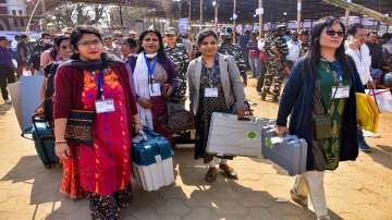 Women poll officials head towards their respective polling stations for the Tripura Assembly elections, in Agartala.