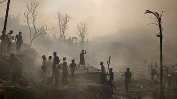 Rohingya refugees try to salvage their belongings after a major fire in their Balukhali camp at Ukhiya in Cox's Bazar district, Bangladesh