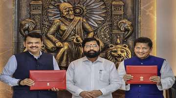 Maharashtra Chief Minister Eknath Shinde with Deputy CM and State Finance Minister Devendra Fadnavis and State Minister Deepak Kesarkar poses for photos with the State Budget 2023-24 during Budget Session of Maharashtra Assembly