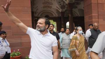 Congress leader Rahul Gandhi waves as opposition MPs walk for a protest over the Adani issue, at Parliament House complex in New Delhi.
