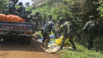 Congolese Defense Forces soldiers remove the bodies of victims of an attack near the town of Oicha.