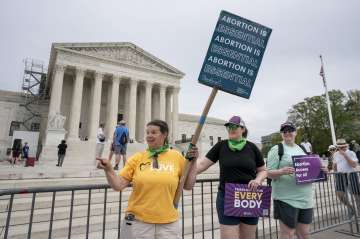 Doris Marlin, left, of Silver Spring, Md., and fellow activists demonstrate in front of the Supreme Court on Capitol Hill in Washington.