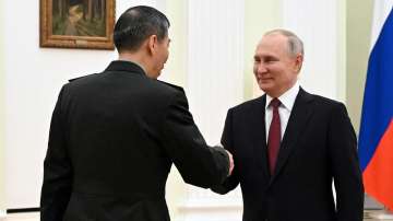 Russian President Vladimir Putin and Chinese Defense Minister Gen Li Shangfu shake hands during their meeting at the Kremlin in Moscow.