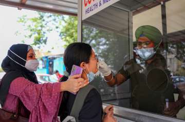 A healthcare worker collects a swab sample of a woman for Covid-19 test, amid a rise in coronavirus cases in the country, in Jammu