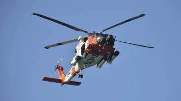 A U.S. Coast Guard helicopter flies over the Venice Fishing Pier Thursday morning, April 6, 2023, as emergency crews search a debris field in the Gulf of Mexico after a small airplane crash Wednesday night.