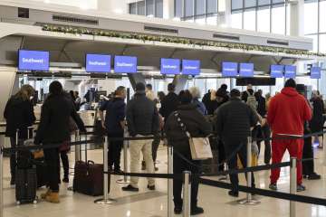 Passengers wait in line to check in for their flights at Southwest Airlines service desk at LaGuardia