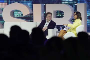 Twitter CEO Elon Musk, centre, speaks with Linda Yaccarino, chairman of global advertising and partnerships for NBC, at the POSSIBLE marketing conference.