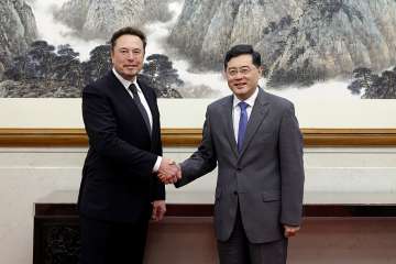 China's Foreign Minister Qin Gang, right, poses for photos with Tesla Ltd. CEO Elon Musk in Beijing. China’s foreign minister met Tesla Ltd. CEO Elon Musk