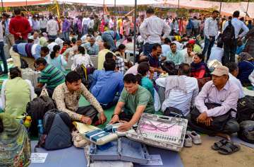 Polling officials collect EVMs and other election materal ahead of the second phase of UP Municipal elections, at a distribution centre in Ghaziabad on May 10