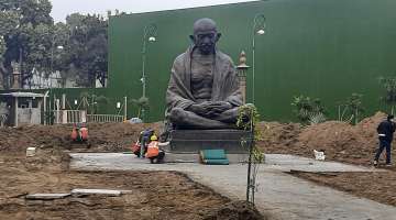 The statue of Mahatma Gandhi being relocated in between Gate No 2 and 3 of Parliament House for the ongoing construction of the new Parliament building, in New Delhi.