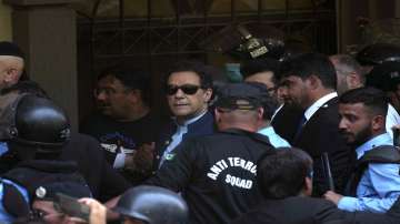 Pakistan's former Prime Minister Imran Khan is escorted by police officers as he arrives to appear in a court, in Islamabad, Pakistan