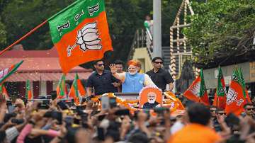 PM Modi waves at supporters during road show ahead of Karnataka Assembly elections in Bengaluru.