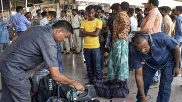 Railway Protection Force (RPF) personnel check passengers bags after the RPF received a threat call to blow up the Patna railway station, in Patna.
