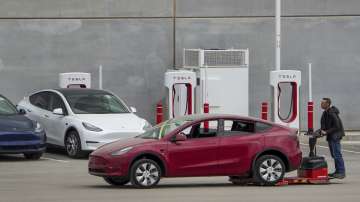 A worker moves a Tesla car at Tesla's Giga Texas automotive manufacturing facility in Austin, Texas.