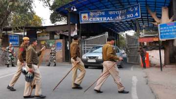 Security personnel stand guard outside at a gate of Tihar Jail. 