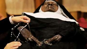 People pray over the body of Sister Wilhelmina Lancaster at the Benedictines of Mary, Queen of Apostles abbey.