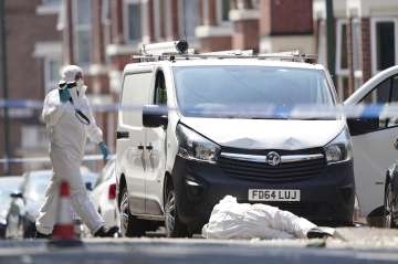 Police forensics officers erect a forensic tent on Magdala road, Nottingham after three people were killed in Nottingham city centre